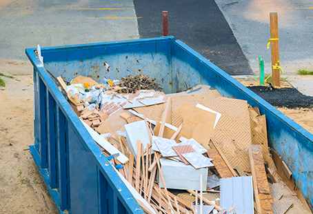 Construction material in blue dumpster